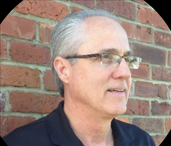 Man in front of brick wall 